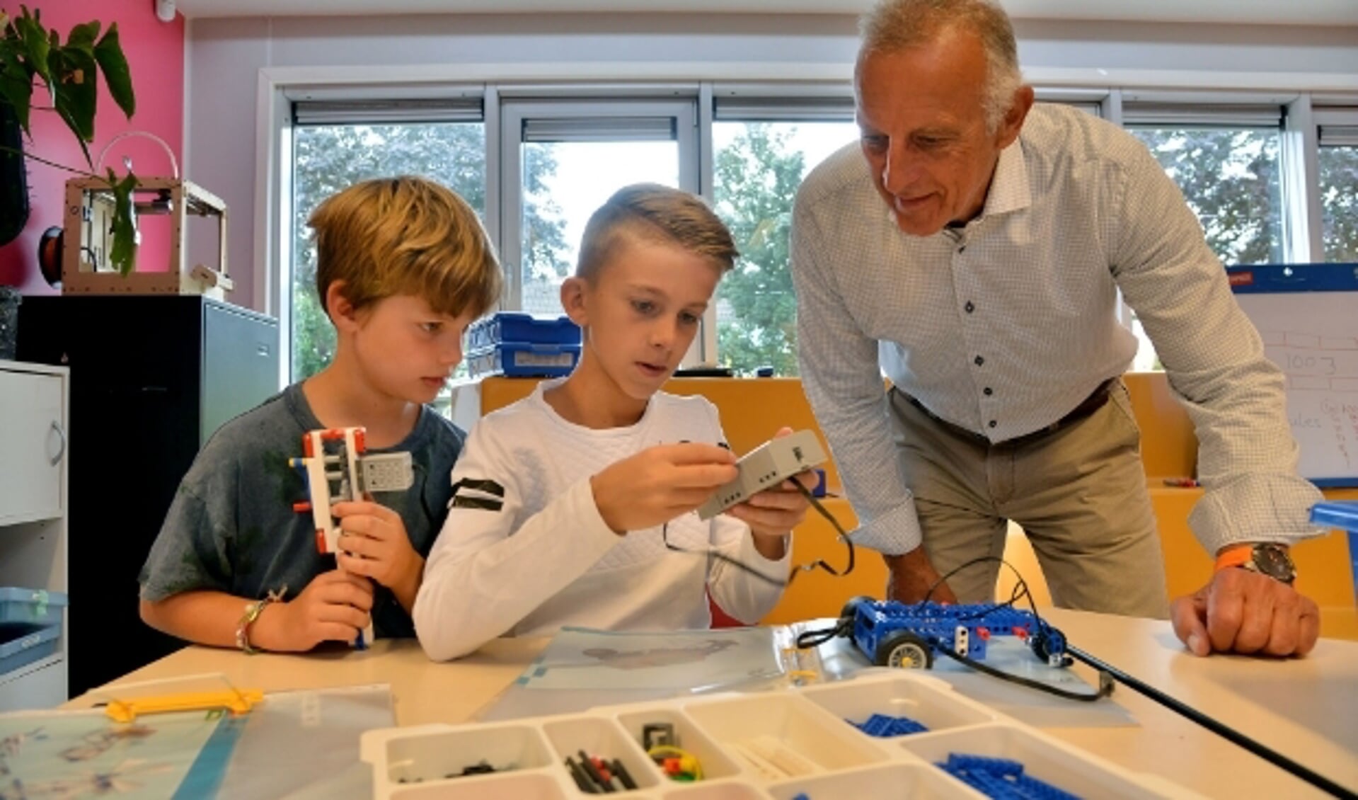 Pedro Jooren kijkt toe als Tjeerd en Dylan tijdens de Techniekles op de Heeswijkschool een elektrische auto bouwen. (Foto: Paul van den Dungen)