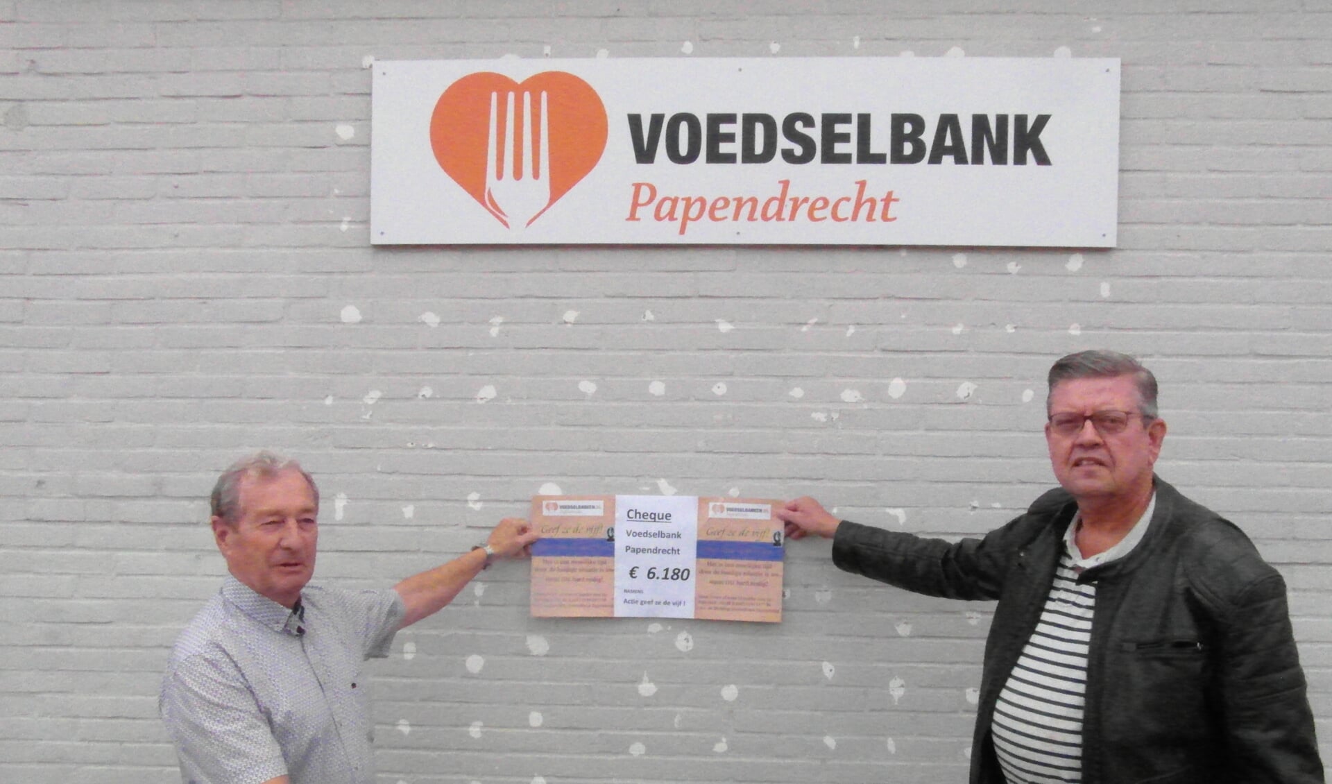 • De overhandiging van de cheque, met rechts Ad Tromp en links Johan Aarnoudse.