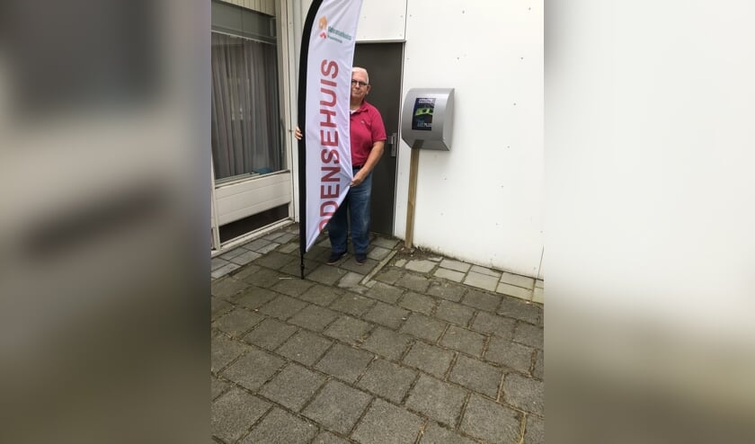 Voorzitter Piet Bezemer toont trots de AED