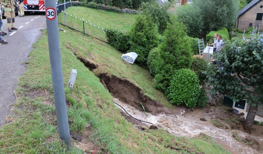• De schade na de breuk in de waterleiding. Hierdoor ontstond een gat in de dijk onder het wegdek.