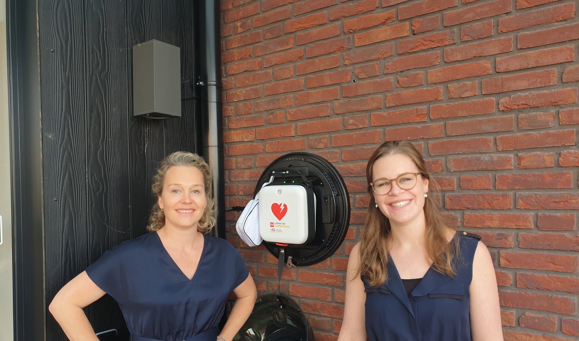 Dokter mevr. Diana de Jonge en Praktijkmanager Nikki de Jong bij de nieuwe AED van d'Alburcht in Wijk en Aalburg.