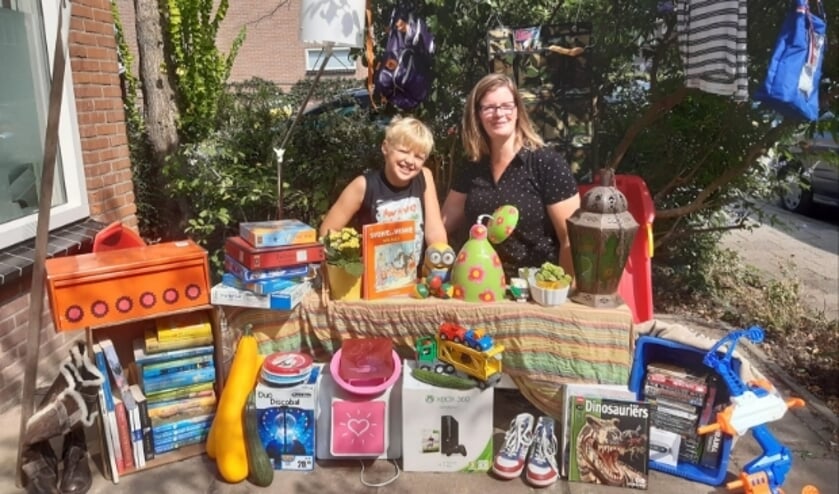 Carola en Koen van Duiven zijn er klaar voor. In hun voortuin maakten ze alvast een leuke rommelmarkt voor de foto. (Foto: Bas van Duiven)