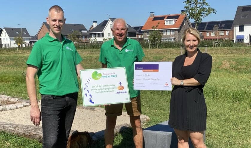 • Dik Groenendijk en Hendri den Otter van het Dorpscomité nemen de cheque in ontvangst van Angelique Muijsson namens Rabobank Lek en Merwede.