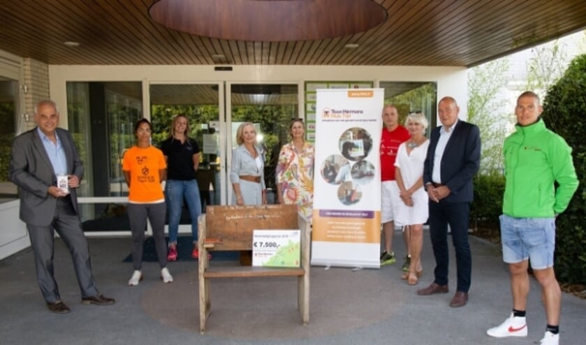 Leden van De Betuwe Runners en leiding van het Toon Hermans Huis Tiel hebben zich rondom de cheque verzameld. (Foto: Wim Brouwers)  