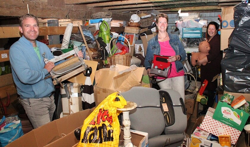 • Roland, Esther en Cora (v.l.n.r.) tussen de rommelmarktspullen, die bij Cora in de schuur opgesteld staan.