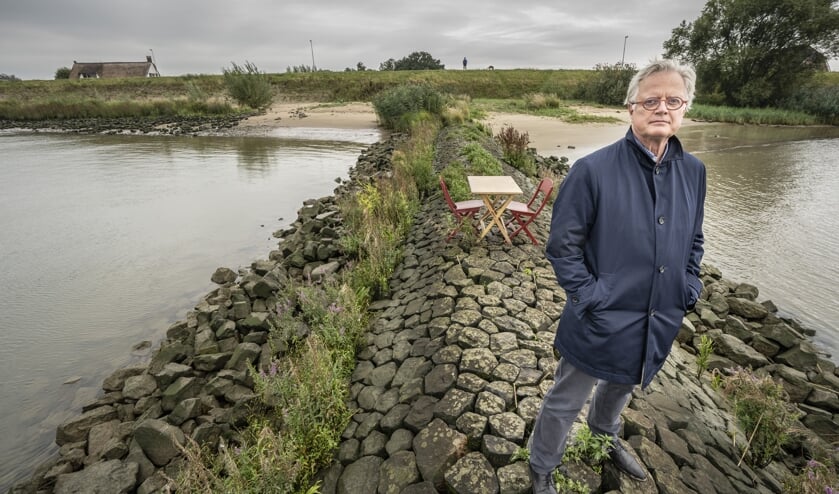 • Deltacommissaris Peter Glas op een krib in de Lek, met veilig achter de dijk een Nieuw-Lekkerlands huis.
