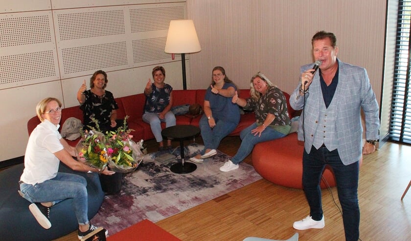 • Ariejanne de Koning van het Havenfestival overhandigt de bloemen tijdens het optreden van Wally.