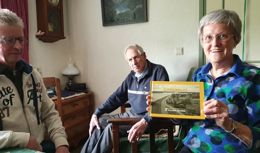 • Janny Manschot neemt het eerste exemplaar van het jubileumboek in ontvangst.