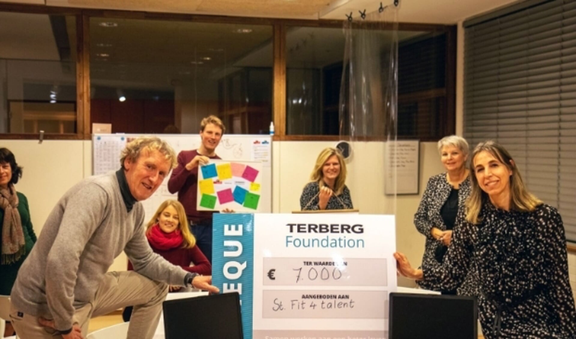 Jan Terberg (links) reikte in de bibliotheek de cheque uit aan Jacqueline Koster (rechts), in aanwezigheid van mede-Foundationlid Freek, docenten en organisatoren van Fit4Talent. (Foto: Terberg Foundation)