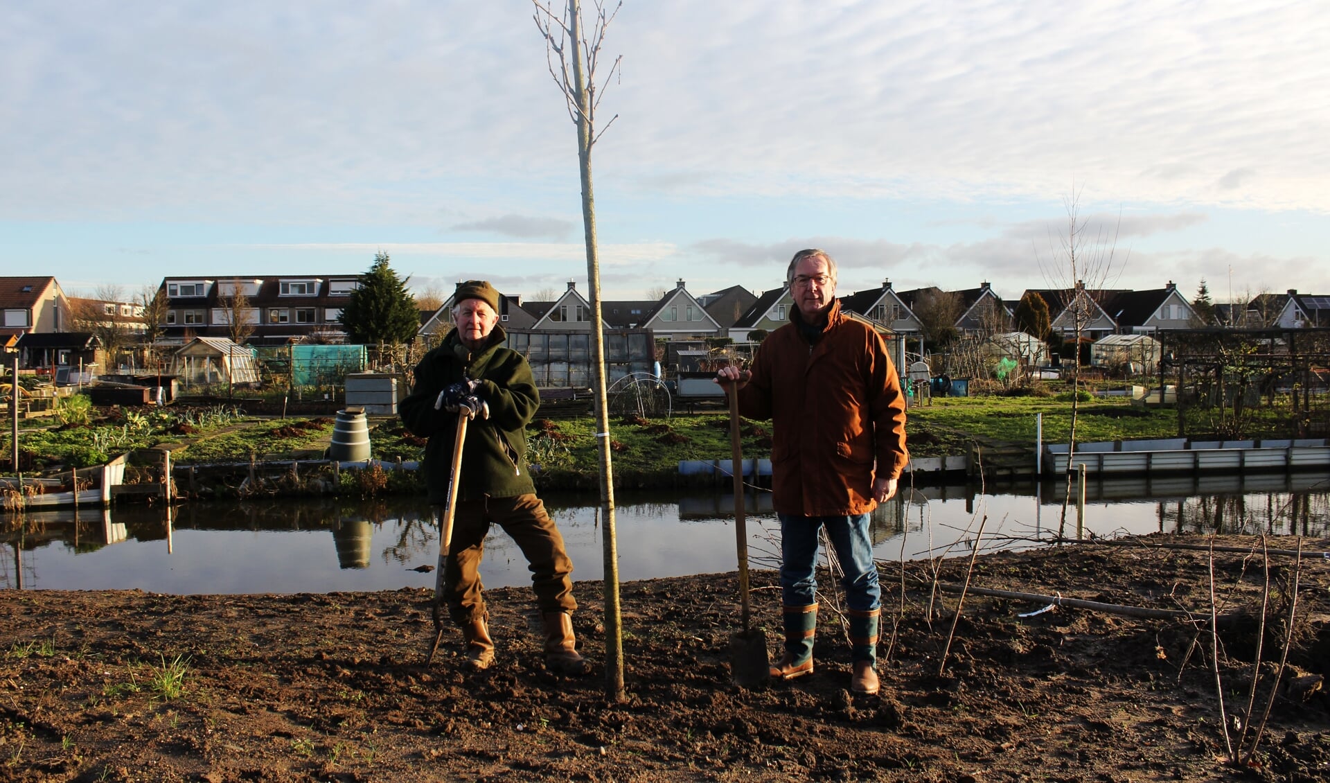Aad den Boer (links) en Peter Janssen (rechts) planten namens de Lions bomen op 'het IJsvogeltje'.