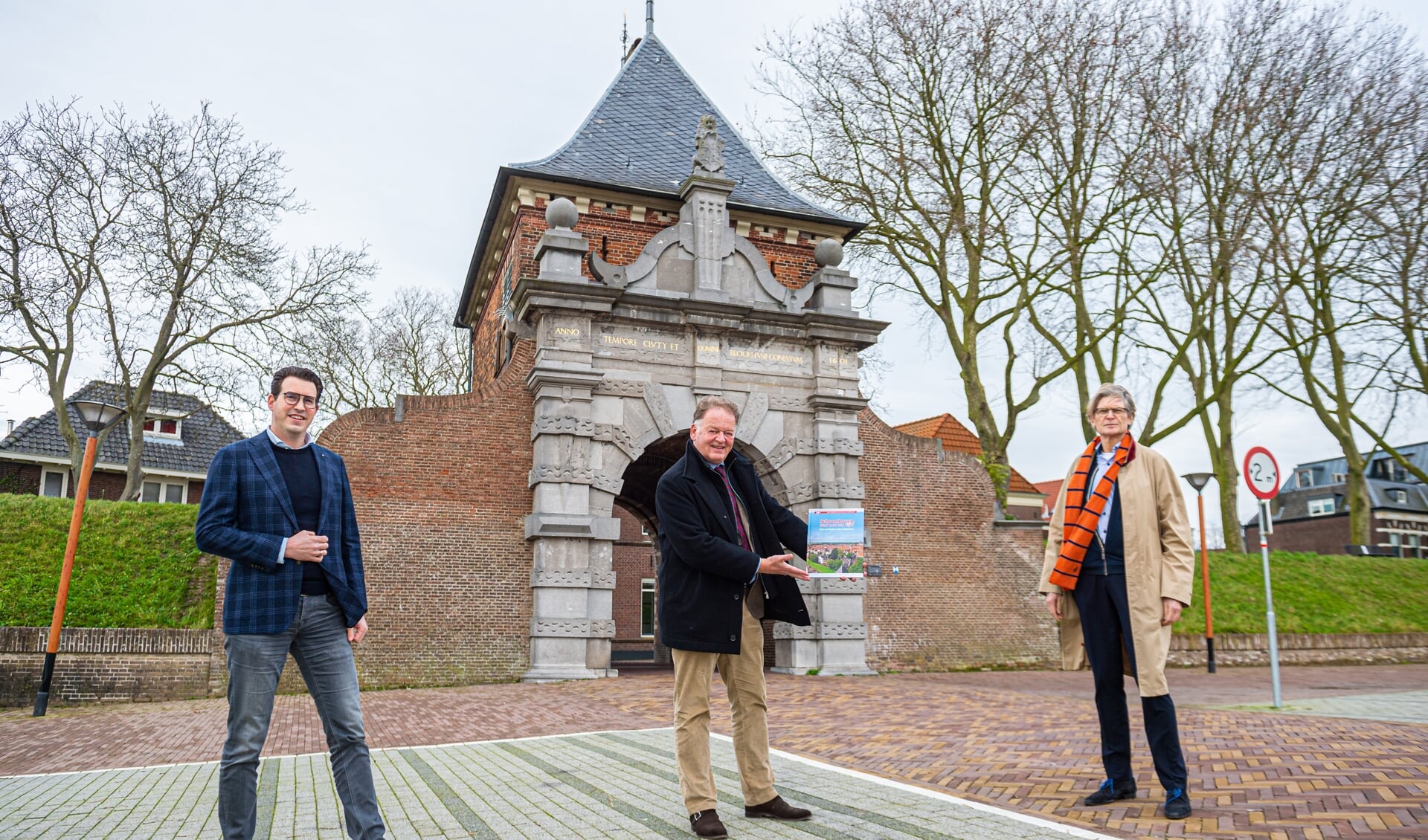 • V.l.n.r.: Bas Rechtuyt, burgemeester Roel Cazemier met het boek en Peter van der Zwaal. 