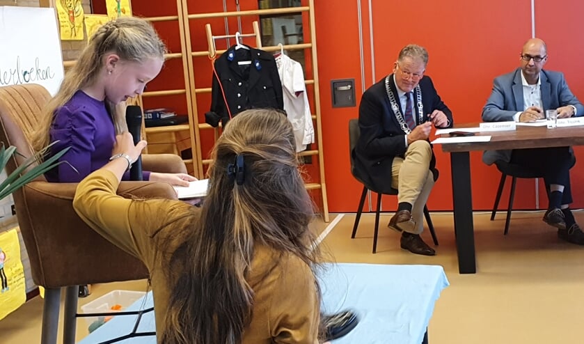 <p>• Tess leest voor, de juryleden Roel Cazemier en Gert Tissink luisteren aandachtig toe.</p>
