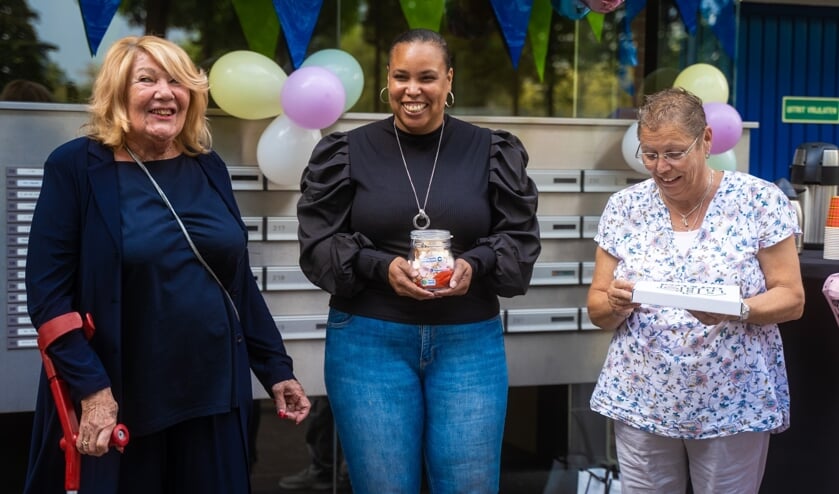 • Wethouder Ans Hartnagel (links) overhandigt het spaarpotje aan bewoners Ilvarette en Anja.