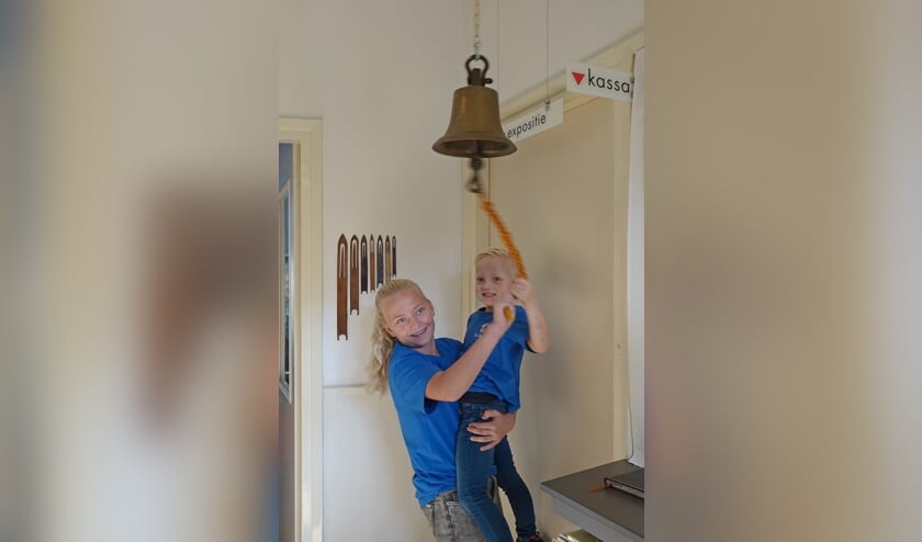 • Aniek Stuij en Stijn Kamphuis luiden de oude schoolbel voor de opening van de nieuwe expositie.