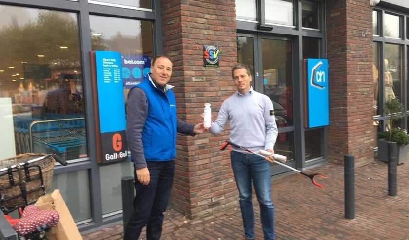 Erik Wiersma ontvangt namens de ondernemers een afvalgrijper van Marco Kortland.