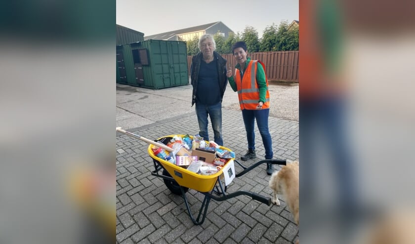 <p>Links Johan de Jong en rechts Anneke Teeuwen. Voor hen de kruiwagen gevuld met voedselwaren.</p>
