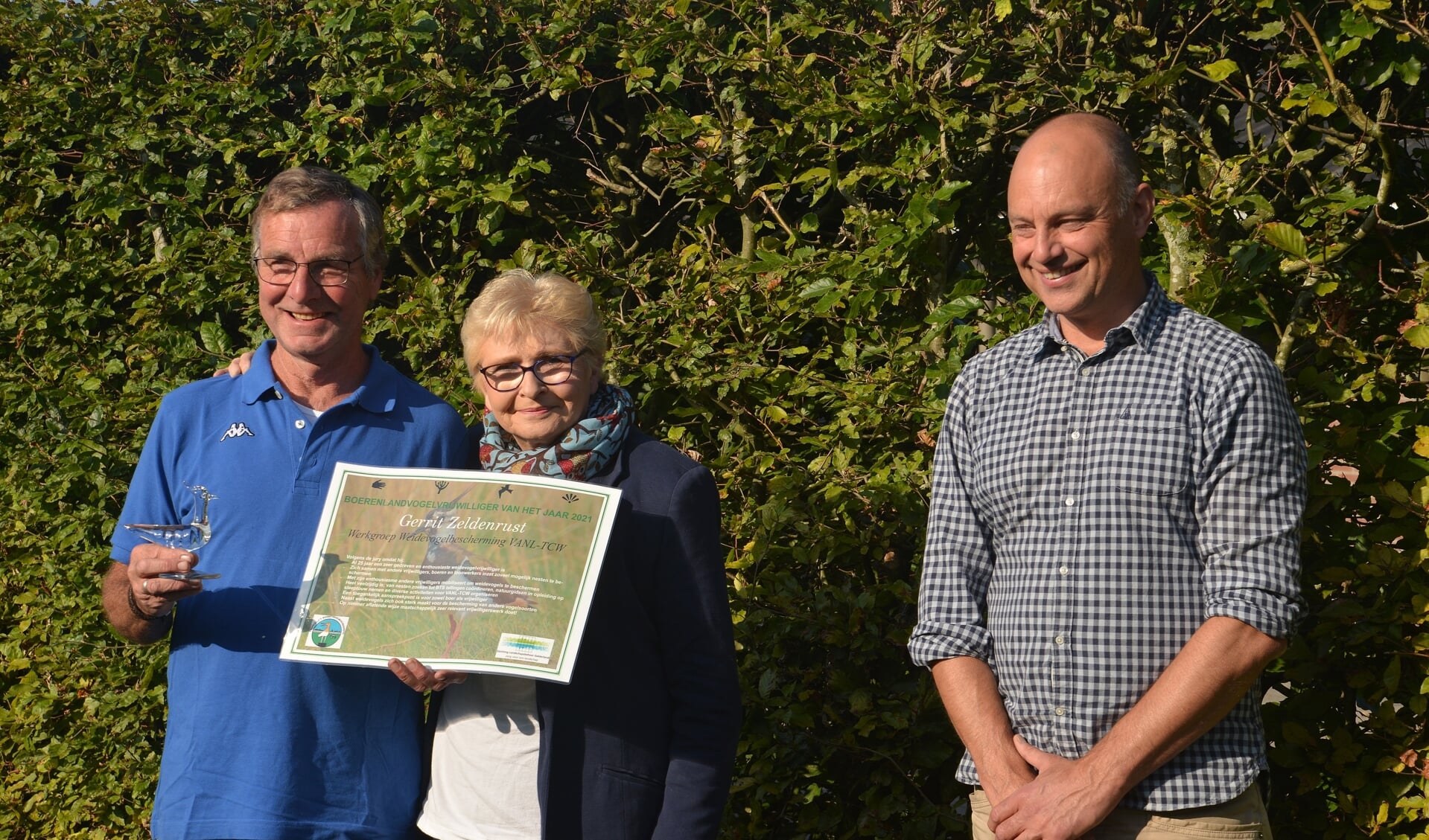• Boerenlandvogelvrijwilliger Gerrit Zeldenrust (links op de foto) met zijn vrouw en Arjan Vriend, directeur-bestuurder van SLG.