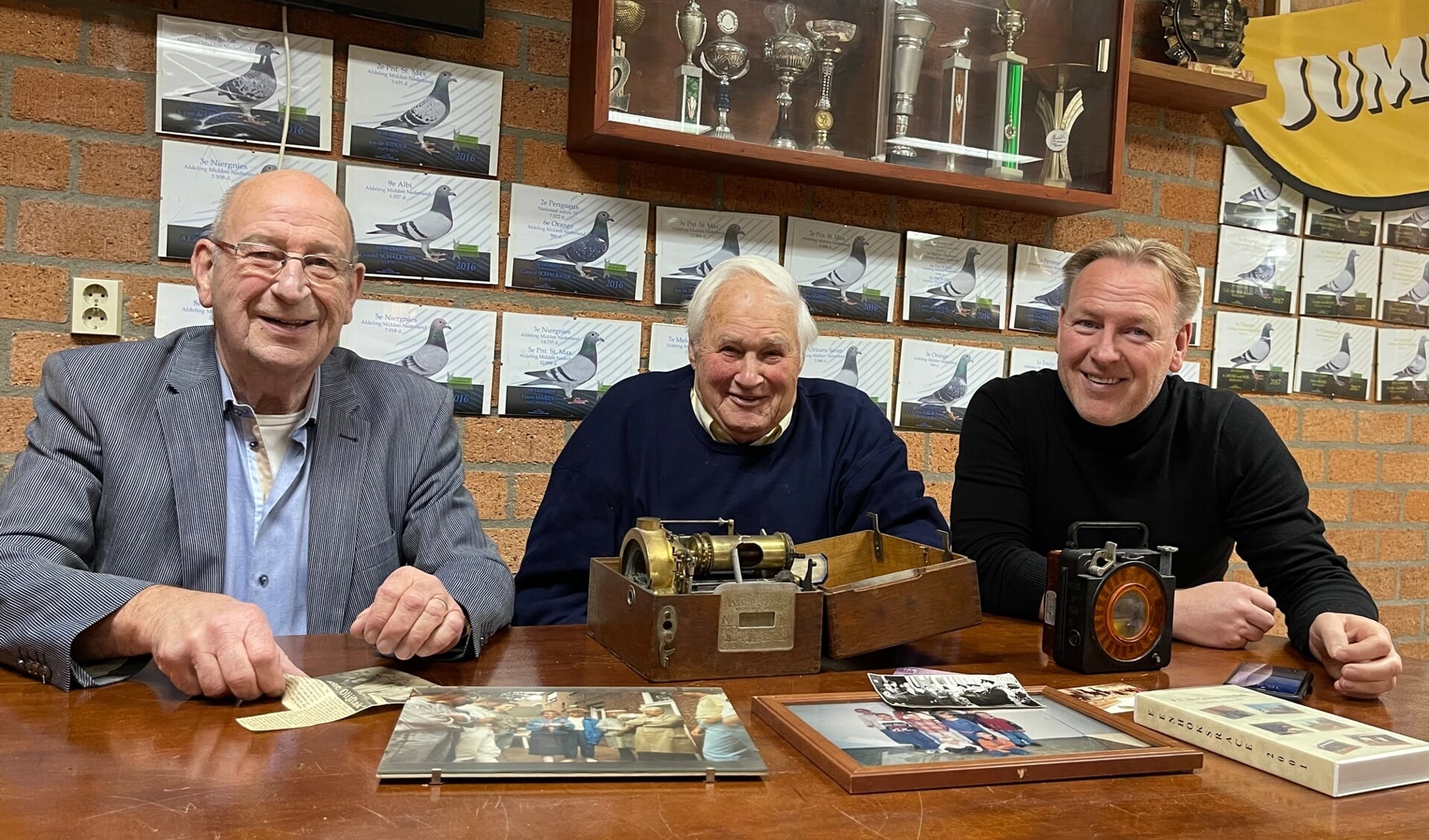 Cees Galjé, Antoon Schalkwijk en Erwin van Wijk halen in het verenigingsgebouw - met foto's en materiaal - herinneringen op aan 100 jaar duivensport bij de Groene Olijftak.