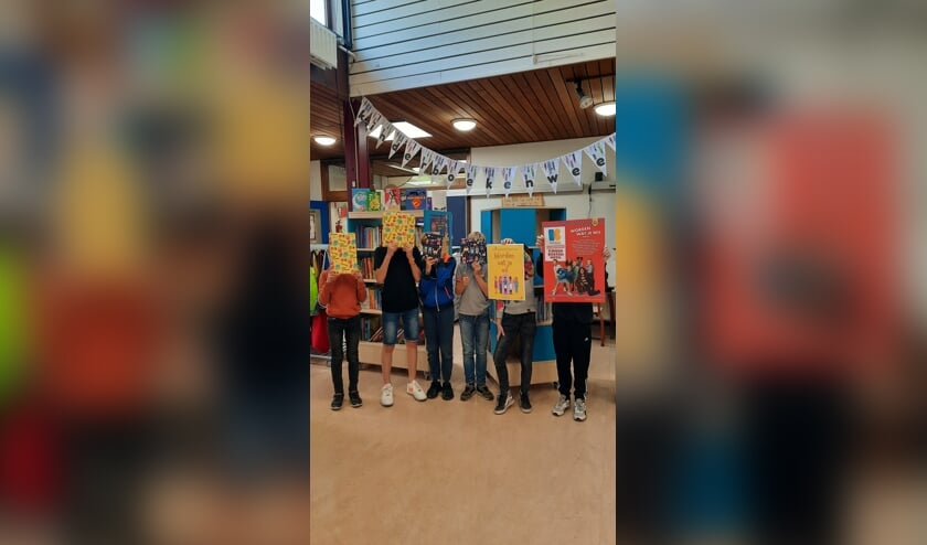De leerlingenraad van De Bloeiende Betuwe deelt cadeaus, vier prachtige boeken, uit om de Kinderboekenweek feestelijk te starten.