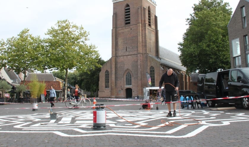 <p>• Het aanbrengen van het doolhof op het Kerkplein zorgde voor veel nieuwsgierige blikken. </p>