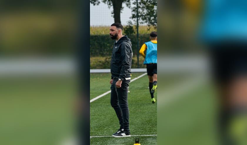 <p>Trainer Hakim Chatouani kijkt naar zijn manschappen.</p>