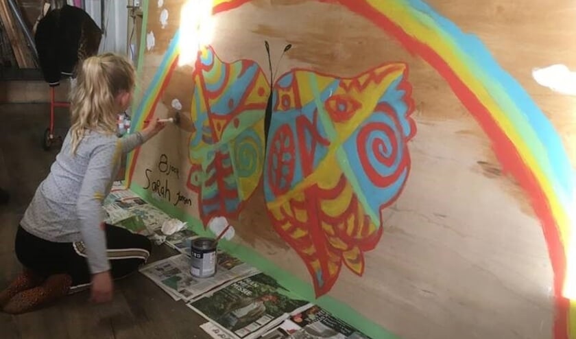 <p>Sarah werkt aan haar schilderij.</p>