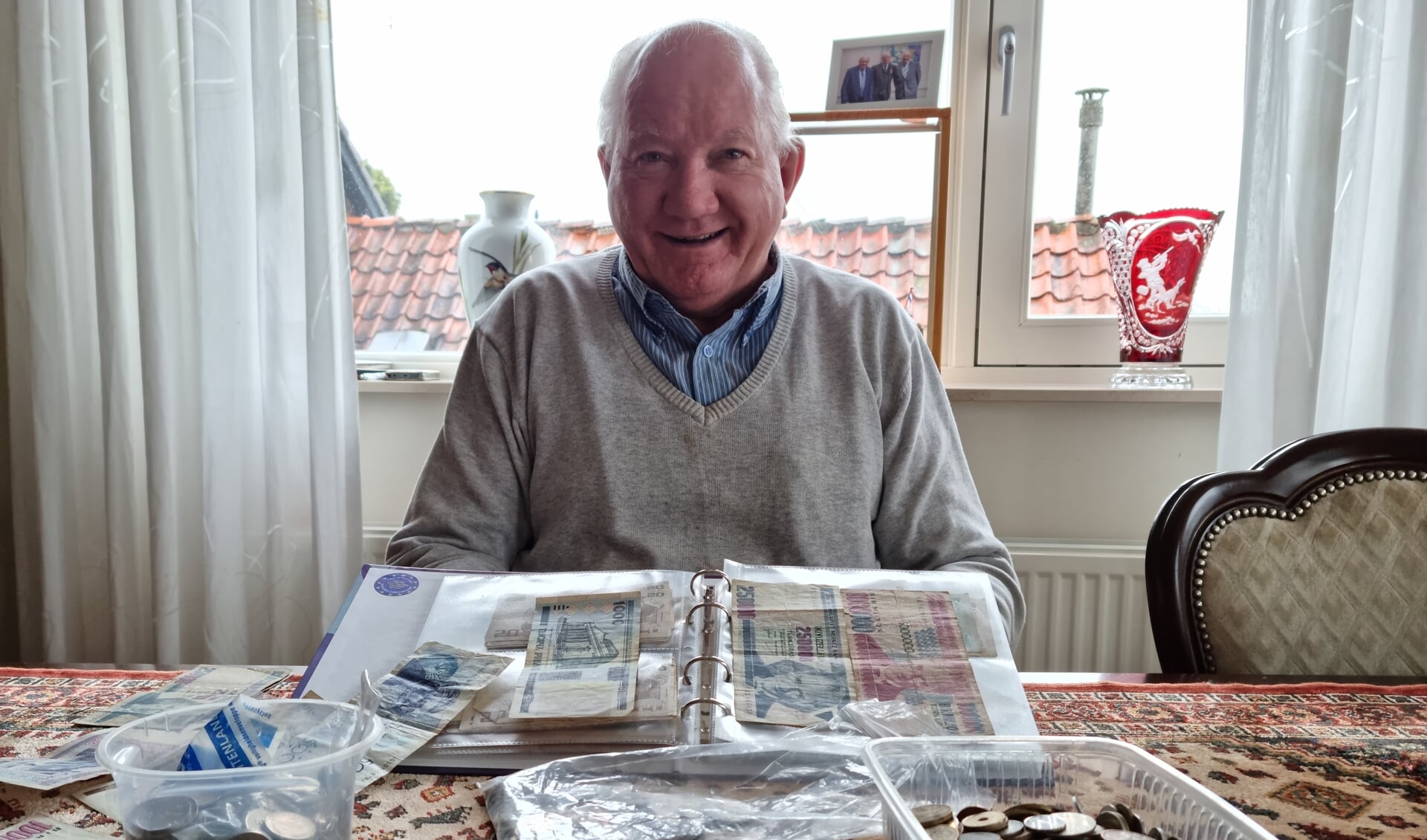 • Gerrit den Hollander met de verzameling oude munten en papiergeld. 