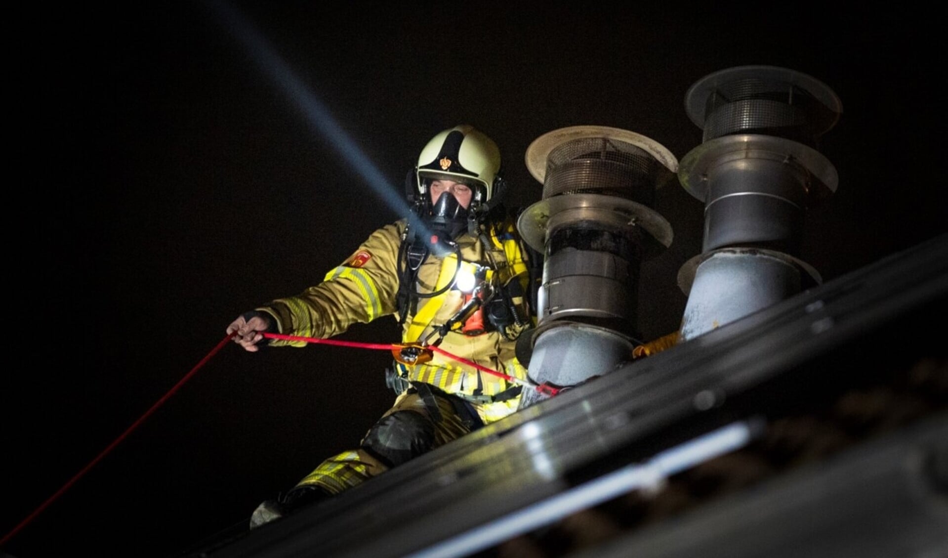 • De brandweer op het dak bij de schoorsteen.