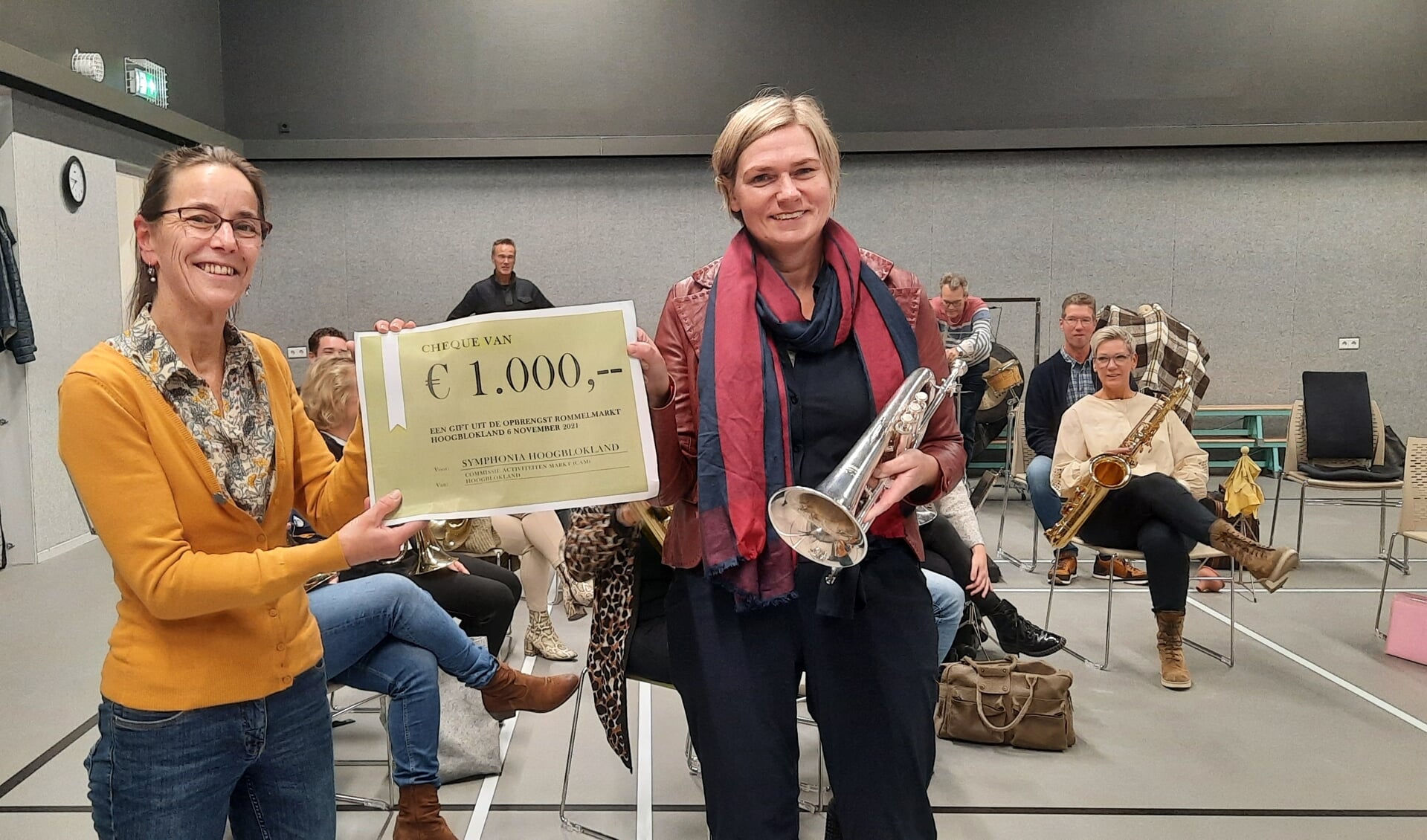 • Voorzitter Els Heuvelman (links) van de Rommelmarkt Hoogblokland de cheque van 1000 euro aan voorzitter Marleen Bakker (rechts) van Symphonia Hoogblokland.