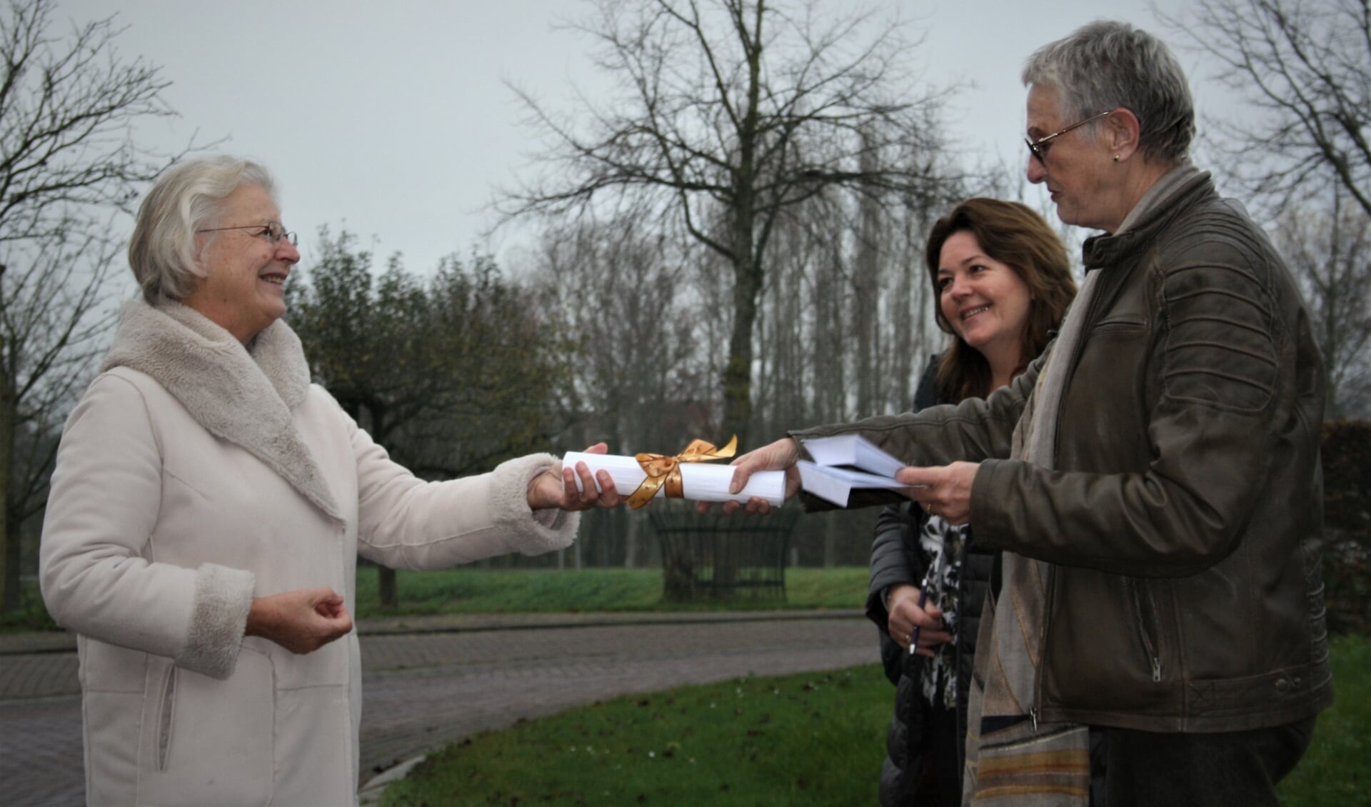 Burgemeester Josan Meijers (links) neemt de handtekeningen in ontvangst van Marieke de Mare (midden) en Thea van der Lee.