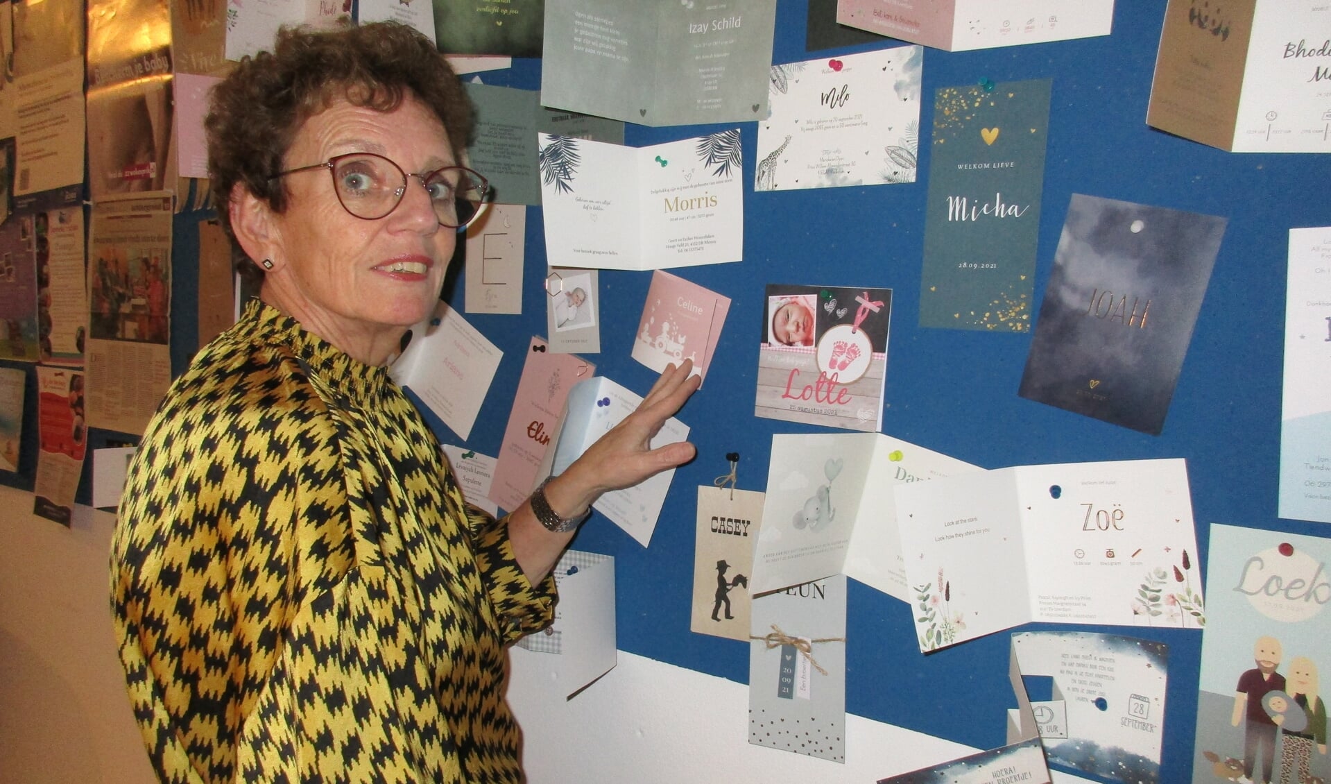 Herma van der Kamp bij het prikbord met geboortekaartjes.