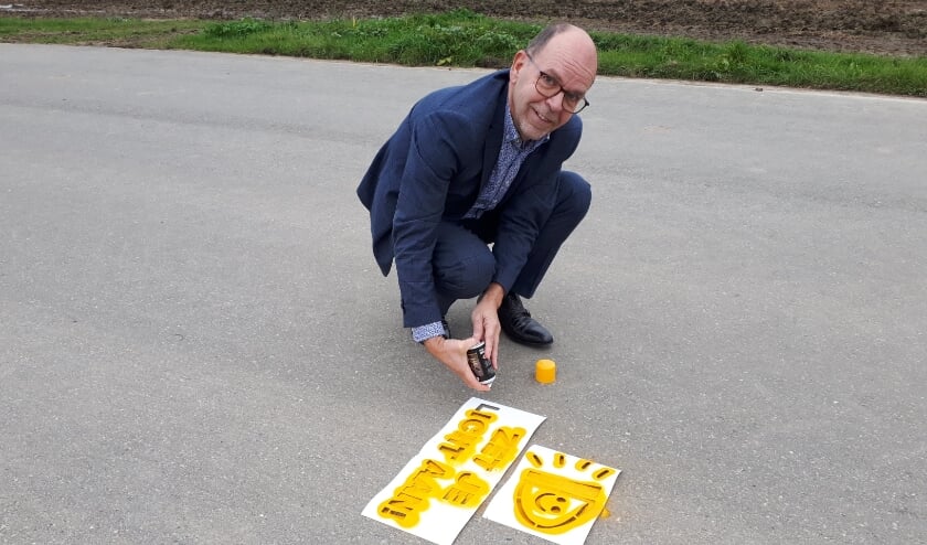 <p>Wethouder Hans Tanis trapte de actie af door en sjabloon op de weg te spuiten.</p>