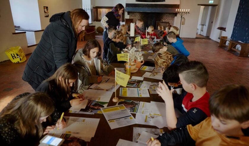 <p>• Scholieren schrijven op Loevestein.</p>