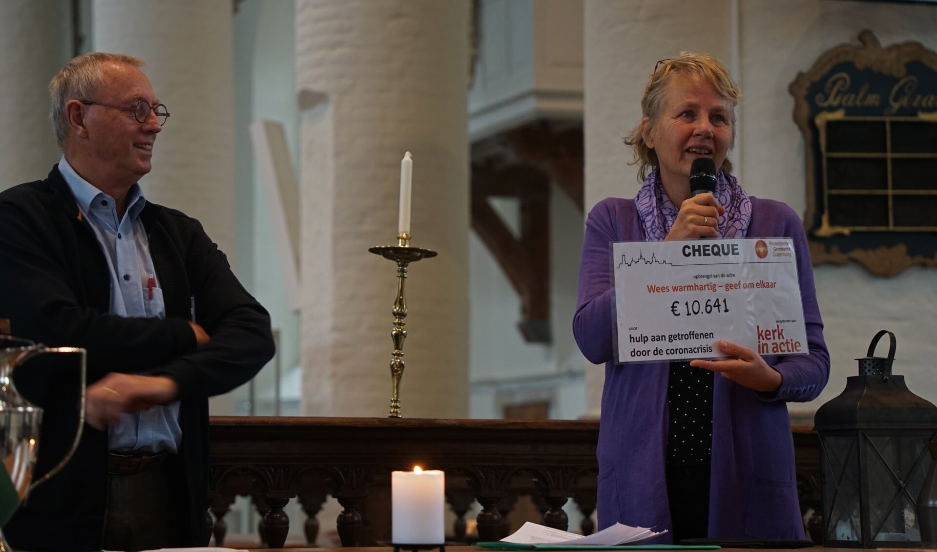 Maaike Wigboldus van Kerk in Actie ontvangt de cheque uit handen van Henk Stokking, voorzitter van de werkgroep Wees warmhartig