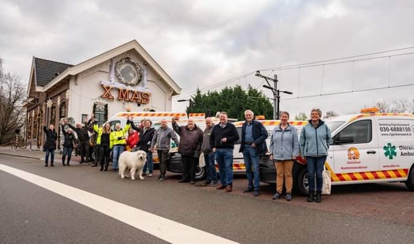 <p>Vrnl: Karin, Sandra en Ton bij de nieuwe auto in Arkel, uitgezwaaid door vrijwilligers van DierenLot.</p>