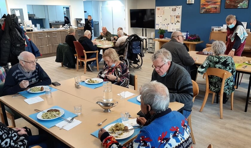 <p>Gasten aan de warme maaltijd bij Inloophuis Tiel, op veilige afstand, vanwege corona.</p>