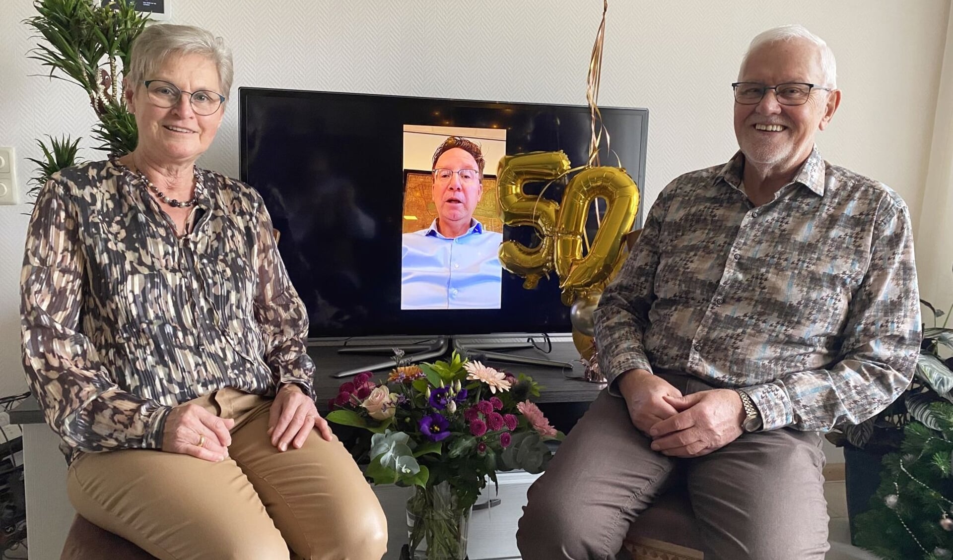 Het gouden paar Joke en Gert van Tuyl met in het midden de burgemeester: online, op afstand.
