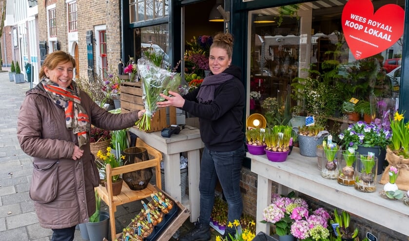 <p>• Michelle van den Berg van Bloembinderij Gewoon Natuurlijk overhandigt een klant een bos bloemen.</p>