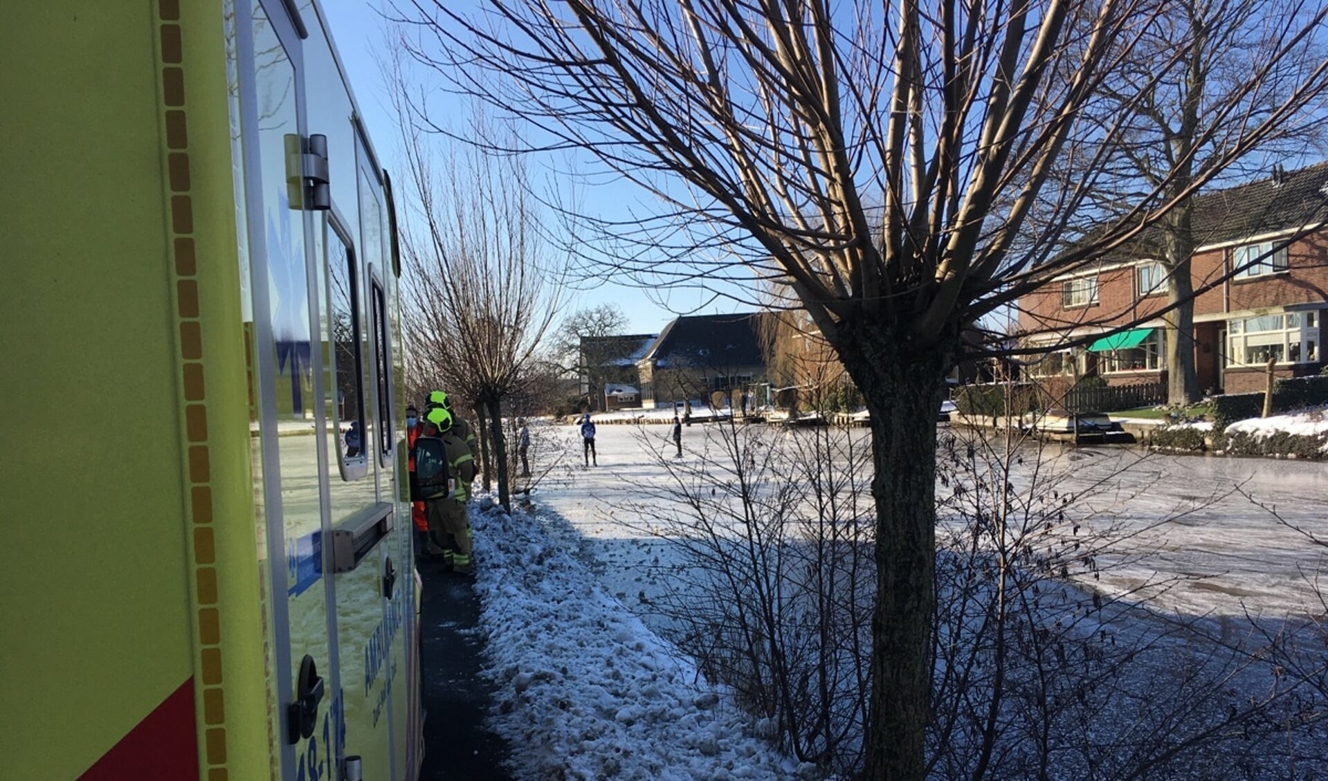 • De ambulance staat langs de Dorpsstraat, schaatsers kijken verschrikt toe.