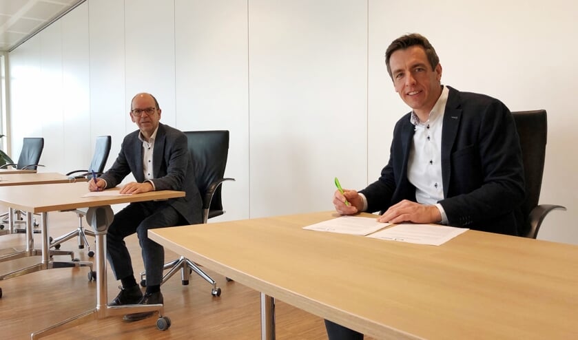 <p>Wethouder Hans Tanis en projectontwikkelaar Van Daalen ondertekenen de overeenkomst voor de bouw van de Poort van Woudrichem.</p>