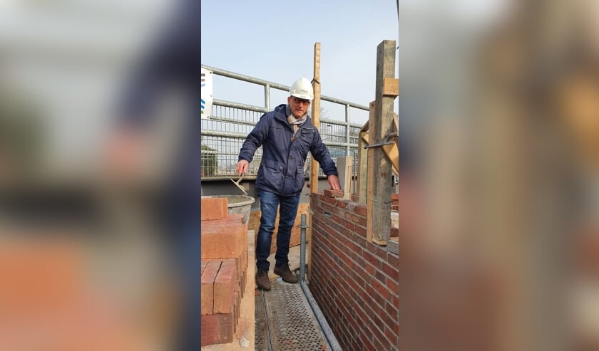 • Wethouder Johan Quik metselt de vleermuizenkast in.