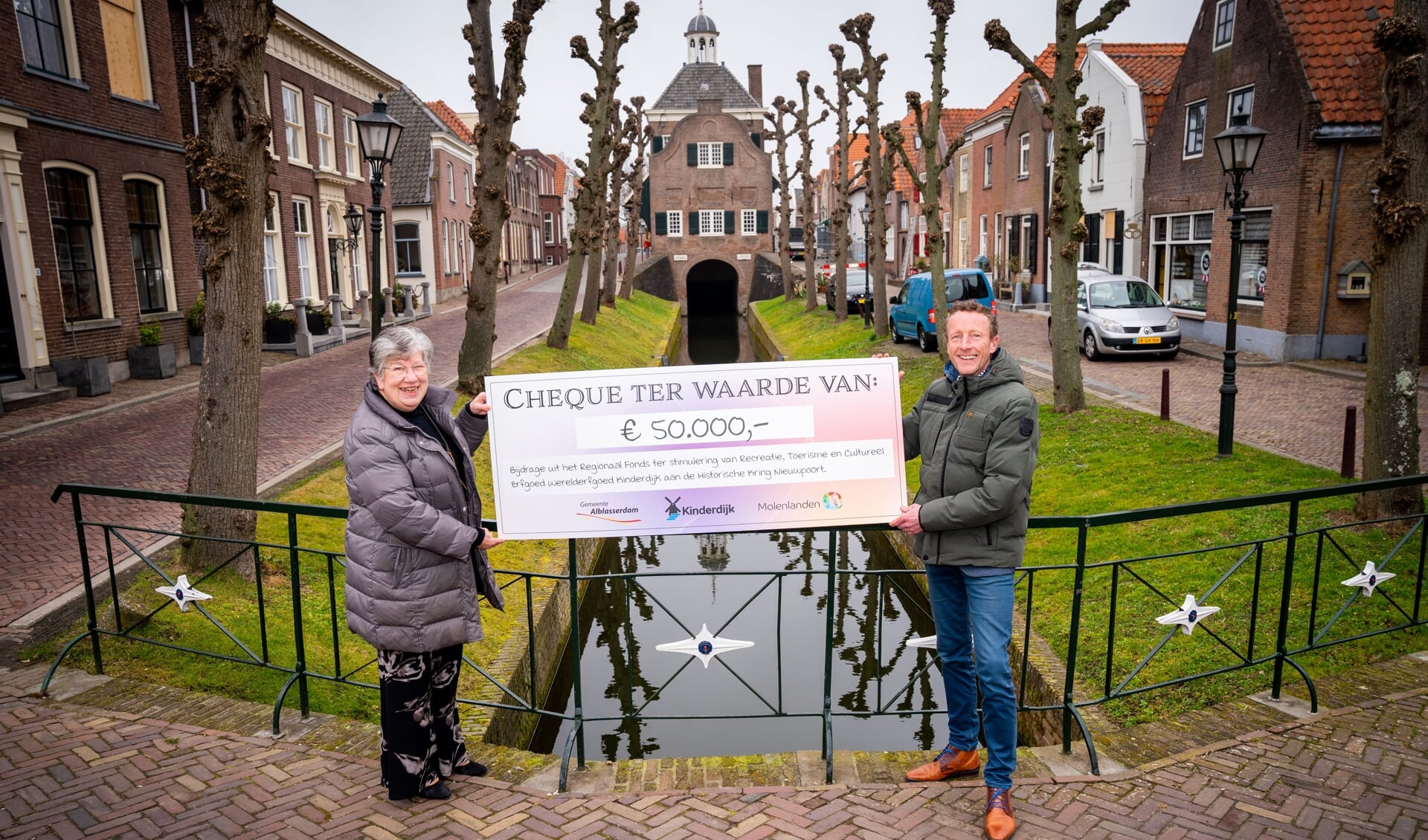• Arco Bikker reikt de cheque uit aan Adrie den Hartog.