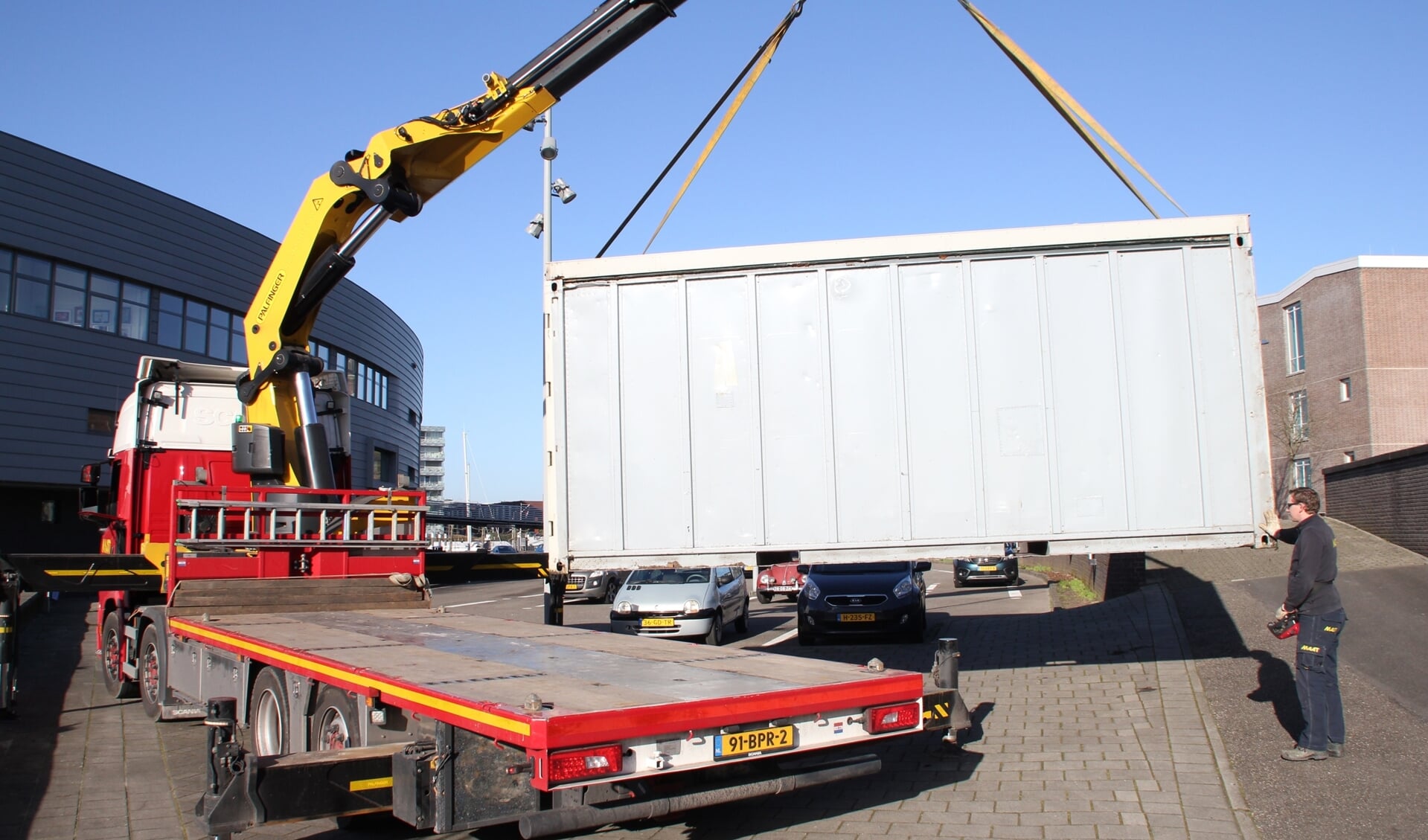 • Eén van de containers wordt op een vrachtwagen van Maat Transport geladen.