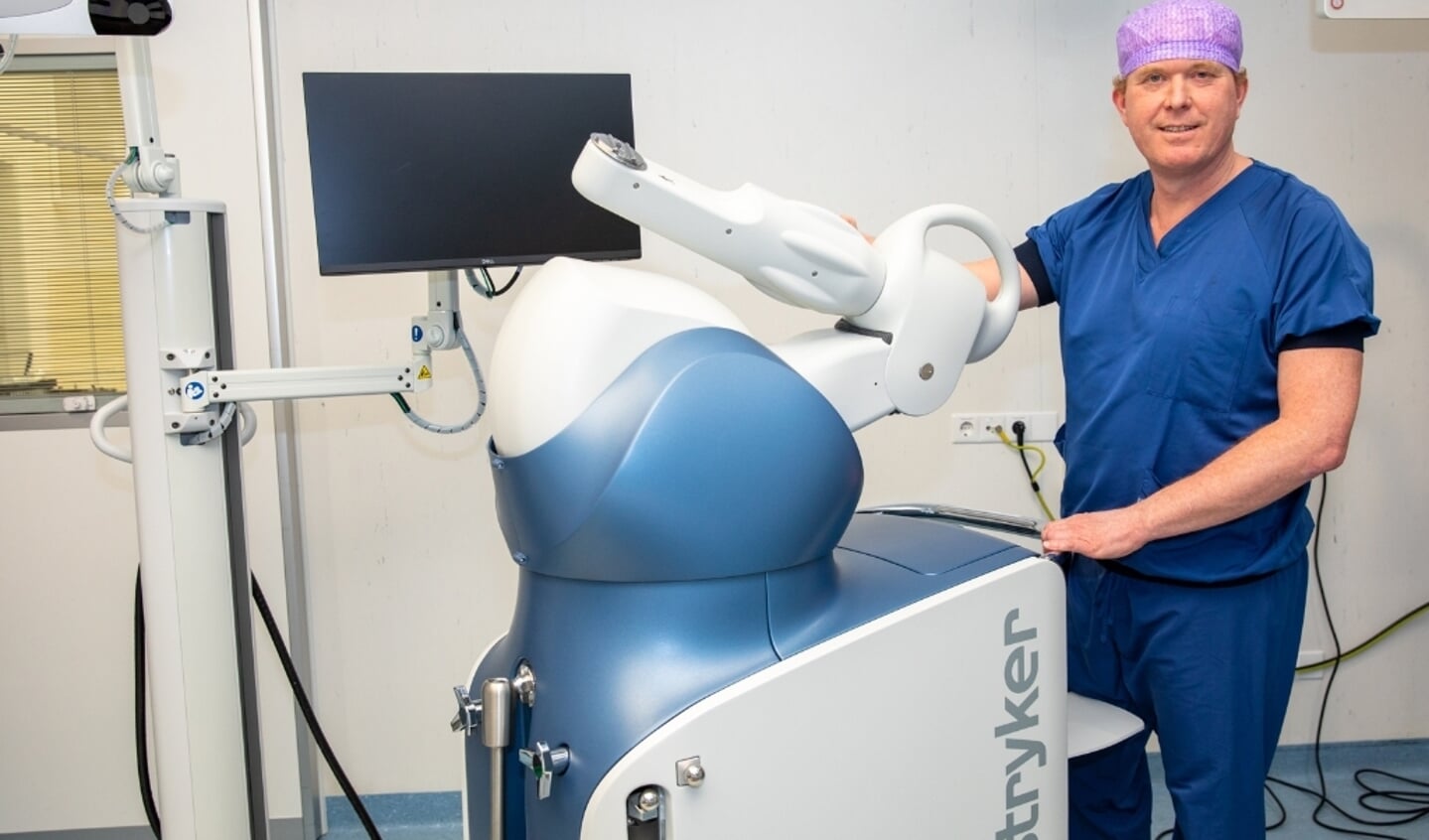 Orthopedisch chirurg Martijn van Dijk met de robotarm. ''Vooral fijn dat patiënten sneller én pijnvrij ter been zijn.''  Foto: PR St. Antonius