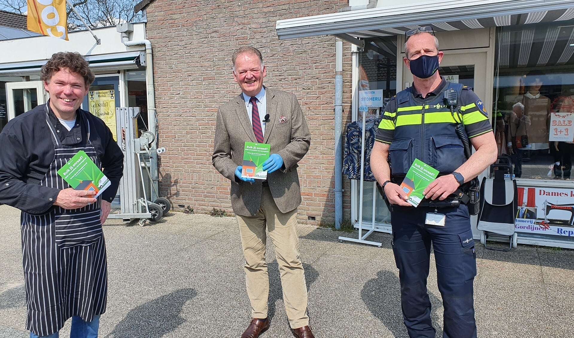 • V.l.n.r.: Slager Willem Markus (hij kreeg de eerste flyer uitgereikt), burgemeester Roel Cazemier en Arjan van Geel namens Politie Krimpenerwaard.