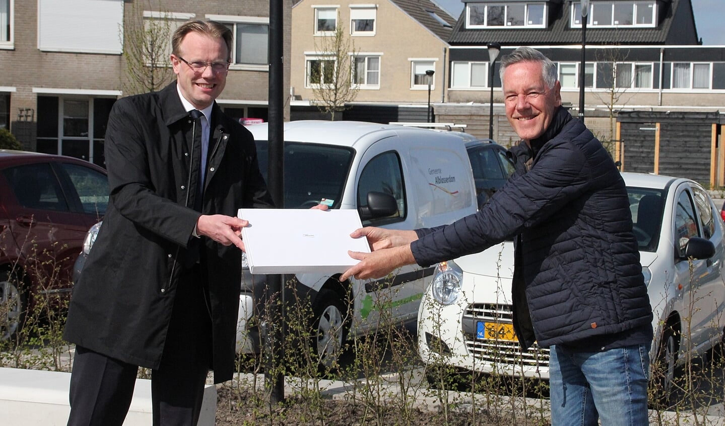 • Een cadeautje van wethouder Peter Verheij (links) voor wijkgroeplid Ronald Vreeman.