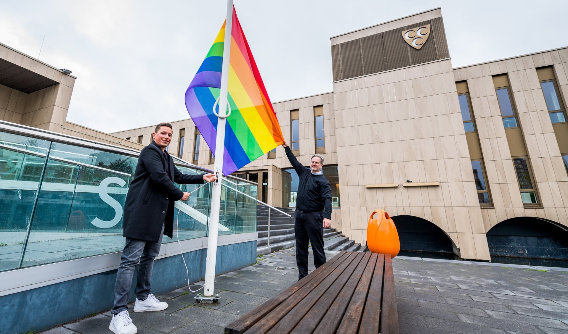 • Wethouder Coen Derickx (rechts) en ambassadeur LHBTI+ Nick Vogelenzang de Jong hijsen de regenboogvlag. 
