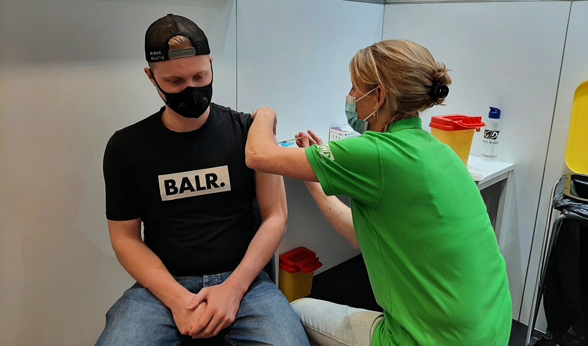 GGD-verpleegkundige Mieke van Eeten uit Giessen zet een coronavaccinatie bij Maarten Korstanje uit Sleeuwijk.