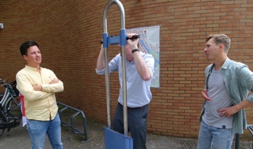 Bas Lont kijkt door de VR paal de geschiedenis in, de makers Jurjan Rietveld (re) en Rick Voll (li)