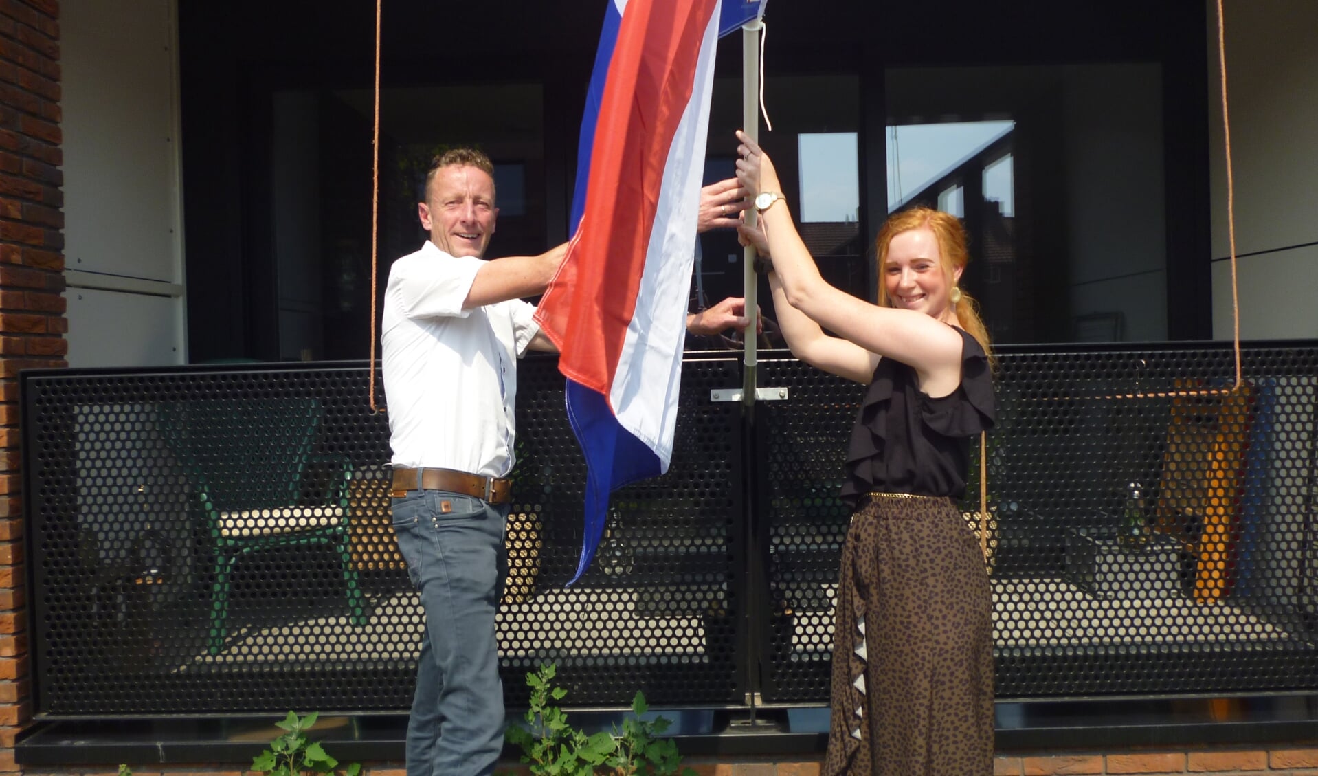 • Wethouder Bikker en huurder Lianne de Haan steken de vlag uit.
